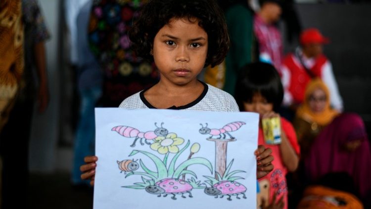 Suminawati, de 9 anos, mostra o desenho que fez no centro em Kalianda, Província de Lampung, após ter sido retirada com sua família da Ilha de Sebesi, atingida pelo tsunami