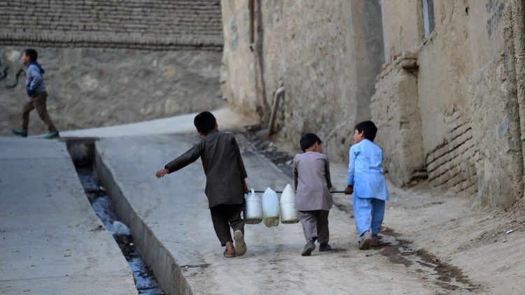 Tri dječaka u Kabulu nose kanistre s vodom