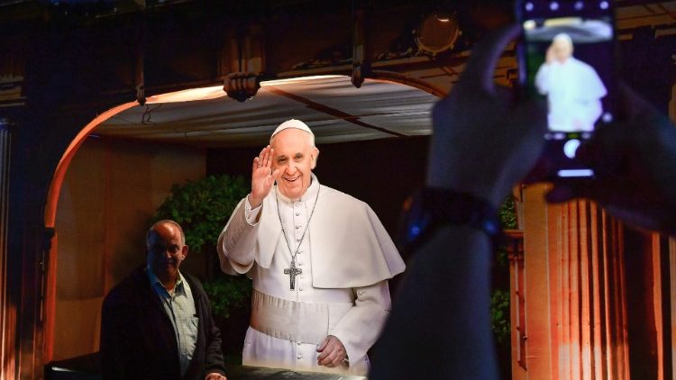 A man takes a photo of an image of Pope Francis at St Mary's Catholic Church in Dubai