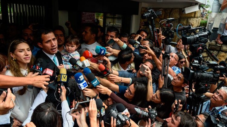 Der Oppositionsführer Juan Guaido, der sich zum Präsidenten erklärt hat, spricht vor seinem Haus mit Journalisten