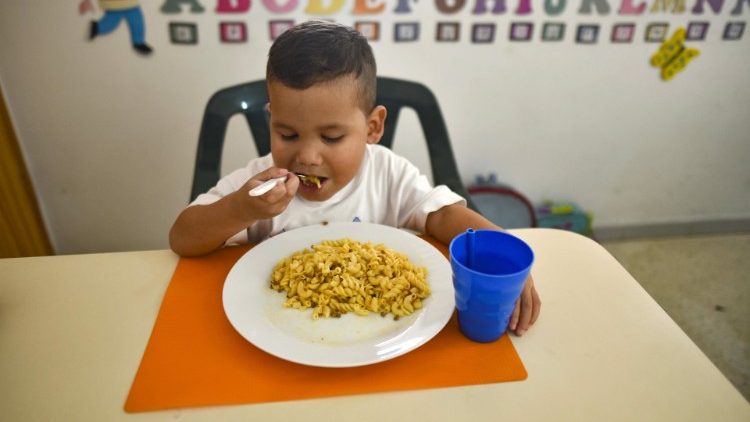Venezuelansk pojke får mat av en hjälporganisation