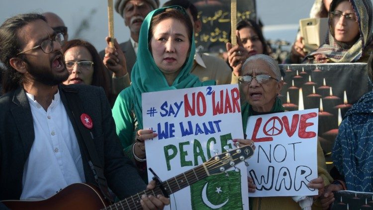 युद्ध नहीं शांति, युद्ध नहीं प्रेम, लिखे बैनर के साथ पाकिस्तान/भारत संघर्ष का विरोध करते लोग