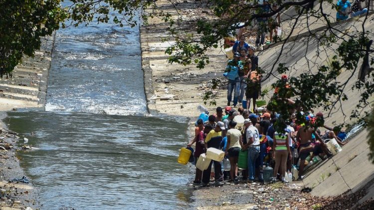 Des personnes puisant l'eau d'une canalisation rompue à Caracas, le 11 mars 2019. 