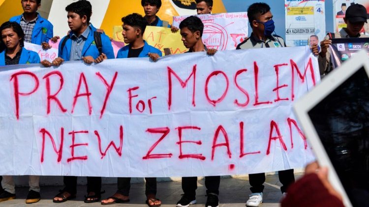 इंडोनेशिया के विद्यार्थी न्यूजीलैंड के लिए प्रार्थना की मांग करते हुए एक बैनर के साथ