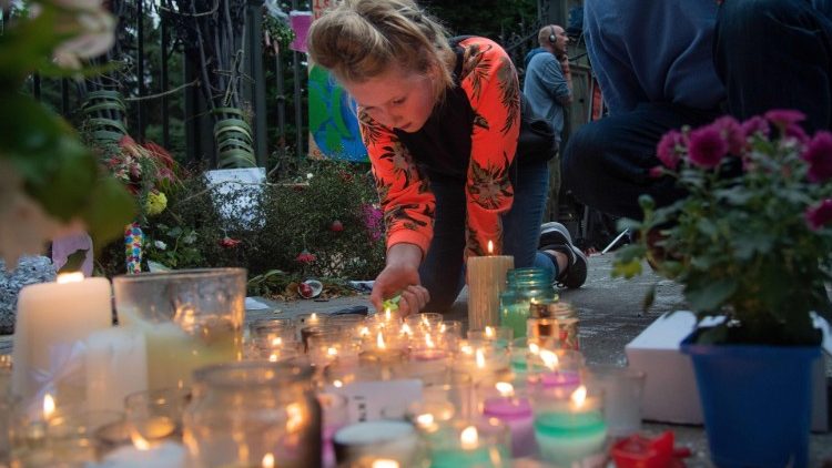 Terror in Christchurch: Ein junges Mädchen zündet an einer Gedenkstätte Kerzen an