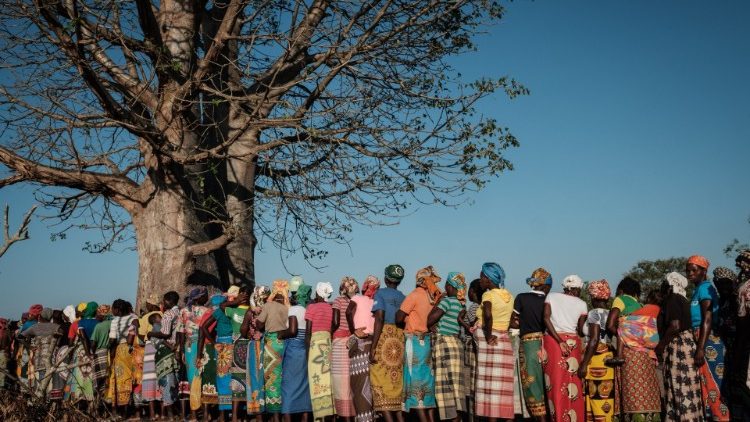 In Mozambique women wait in line to receive relief supplies after Cylone Idai