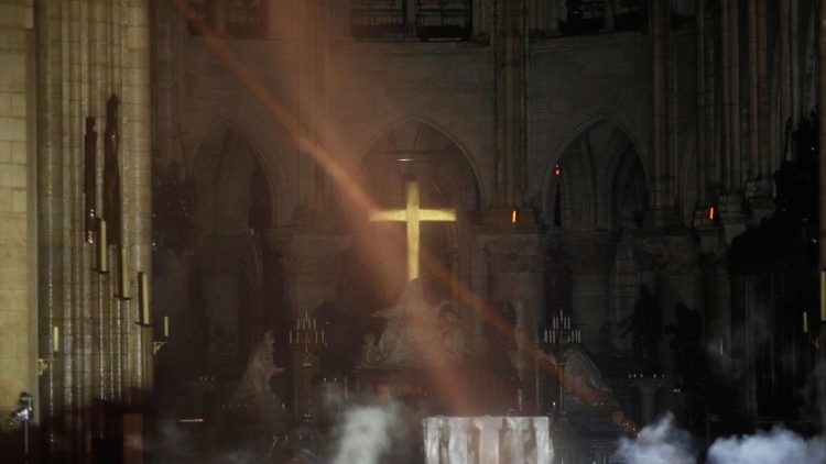 Smoke rises around the main altar and cross inside Paris' Notre Dame Cathedral