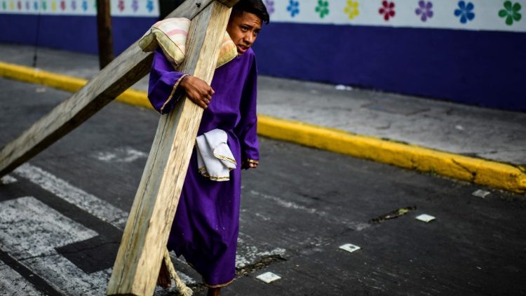 一位墨西哥年輕人在聖週五背十字架拜苦路