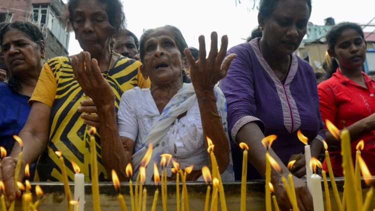 Cristãos cingaleses acendem velas próximo a uma barreira policial após atentatos no Santuário Santo Antônio, em Colombo, Sri Lanka