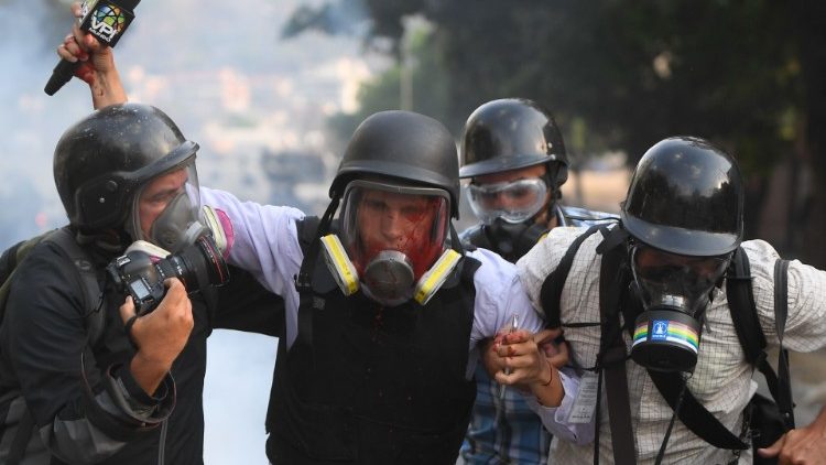 Journalister springer från tårgasrök vid demonstration 1 maj i Venezuela