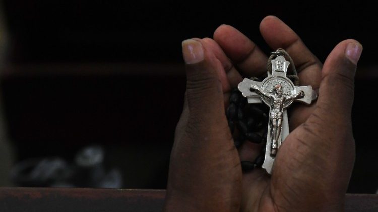 Fiel cingalês con crucifixo na catedral de Santa Lucia, em Colombo