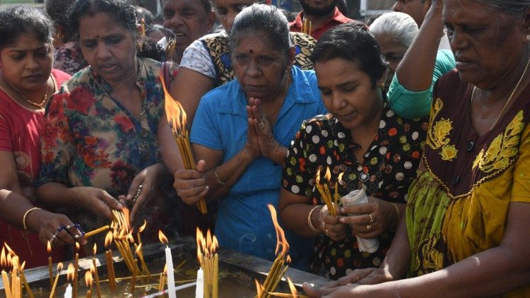 Fiéis católicos cingalesesa acendem velas diante da Igreja de Santo Antônio, em Colombo
