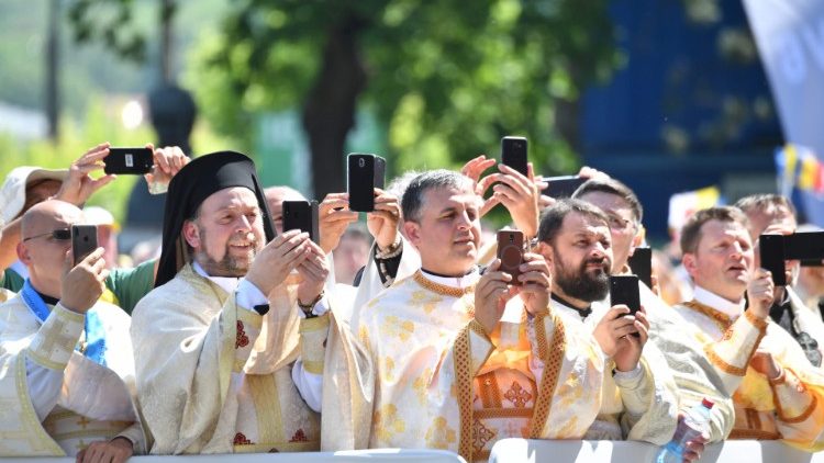 Des prêtres gréco-catholiques prenant le Pape en photo avec leur smartphone lors de la Divine Liturgie célébrée à Blaj, en Roumanie, le 2 juin 2019.
