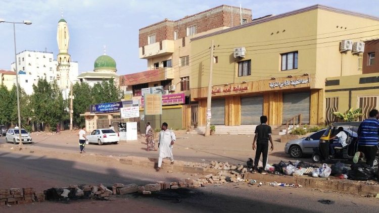 Sudanese men block a suburban road in Khartoum