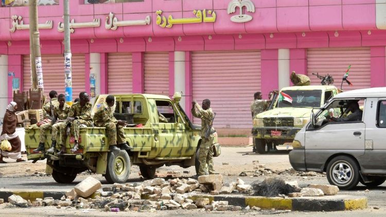 Sudanese soldiers stand guard a street in Khartoum