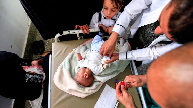 यमन में संघर्ष के दौरान के बीमार बच्चे की मदद करते चिकित्सक