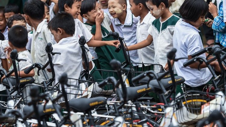 म्यामांर में साइकिल से स्कूल आते बच्चे