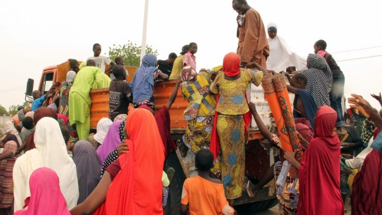 Internally displaced people try to climb a lorry to protest against food shortages, Maiduguri, Nigeria