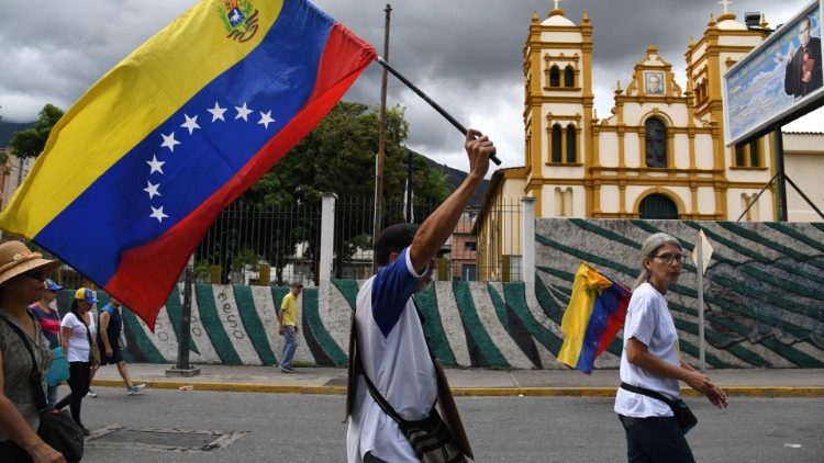 Превърженици на опозицията манифестират с националния флаг на Венецуела.