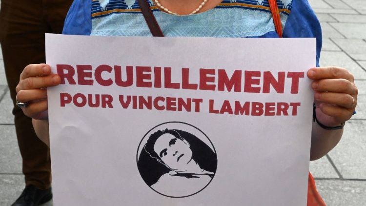 Devant l'église Saint-Sulpice, une femme invite à se recueillir pour Vincent Lambert, le 10 juillet à Paris