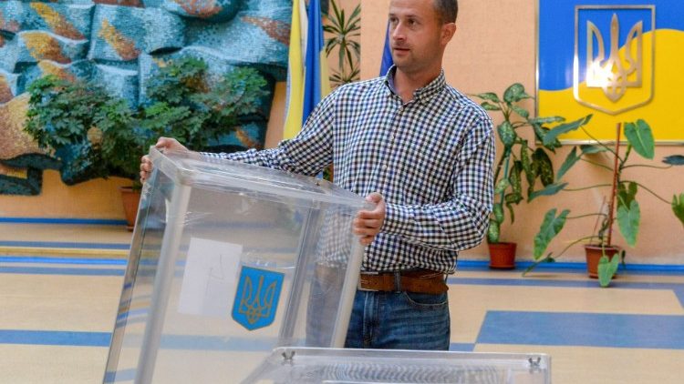 Un membro di una commissione elettorale allestisce le urne in un seggio elettorale nel centro di Kiev 