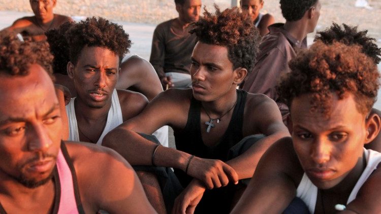 Спасени мигранти седат на брегот на Кхомс околу 100км од Триполи
