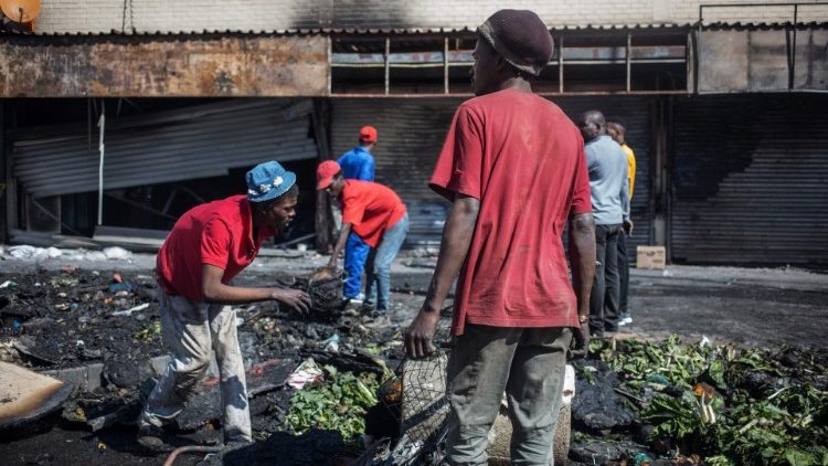 People rummage through looted foreign-owned shops in Alexandra Township, Johannesburg