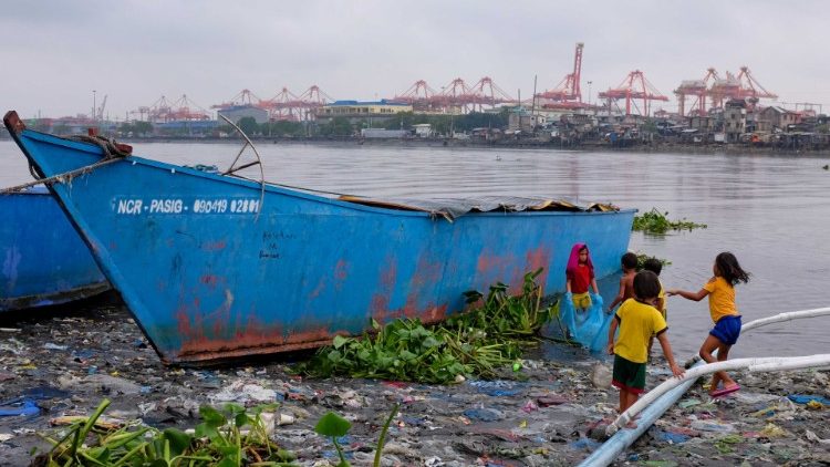 Djeca iz slama se igraju na obali teško zagađenog zaljeva u Manili