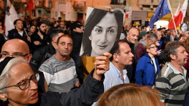 Maltese citizens hold placards of Daphne Caruana Galizia during a protest
