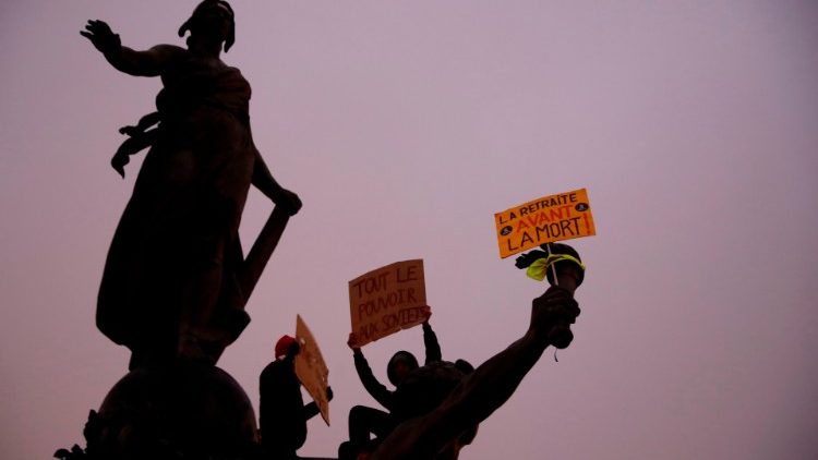 Protesters stand on the "Triomphe de la Republique" statue holding banners during a rally against the pension overhauls 