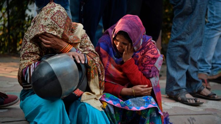 Parenti di alcune vittime dell'incendio di New Delhi
