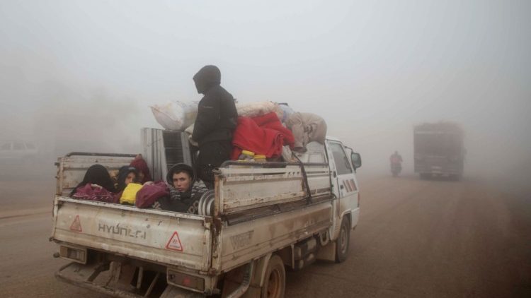 Syrians carrying their belongings drive towards the northern areas of Syria's Idlib province