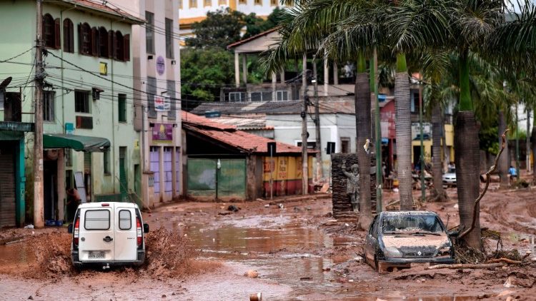 Caminhão percorre uma rua inundada após o transbordamento do Rio das Velhas, em Sabara (MG)