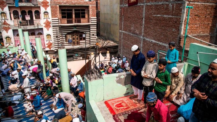 Los devotos musulmanes ofrecen las oraciones de los viernes en el techo de la mezquita después de los disturbios por la nueva ley de ciudadanía de la India