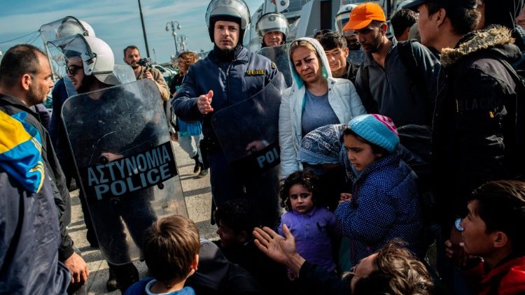 Sur le port de Lesbos, le 3 mars 2020, des policiers grecs tentent de bloquer des personnes migrantes.