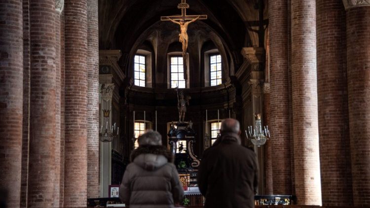 Un couple prie dans une église d'Asti, au nord-ouest de l'Italie, dans une région mise sous quarantaine, le 8 mars 2020.