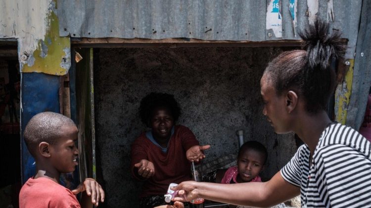 Voluntária de uma ONG local distribui desinfetante para as mãos na periferia de Nairóbi, Quênia