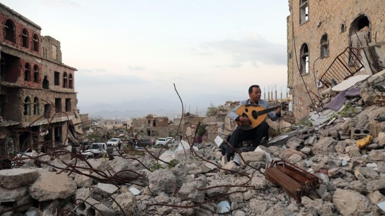 Un homme joue de la guitare sur les décombres de la ville de Taez, troisième ville du Yémen, en décembre 2019.