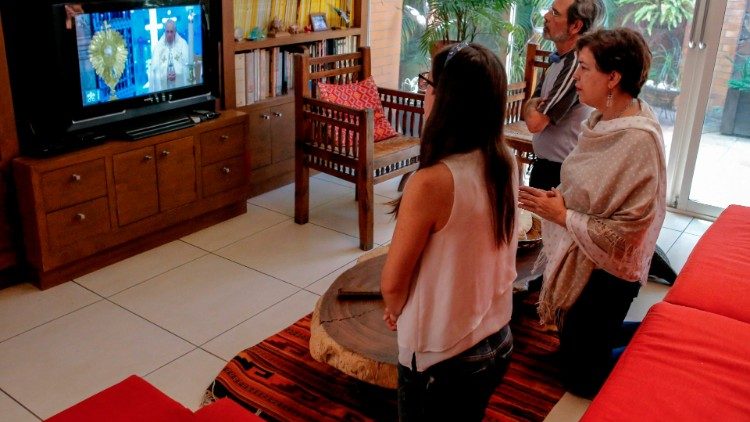 Uma família do México rezando com o Papa através dos veículos de comunicação