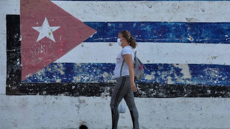 Cubana protegida por máscara caminha em rua de Havana 