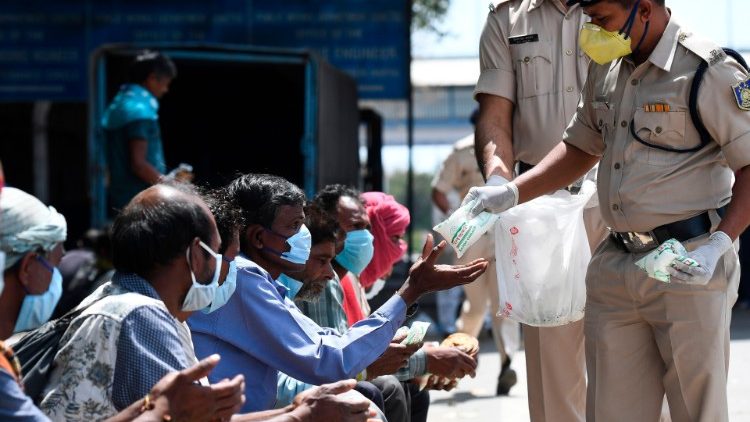 Police distribute food to homeless people during lockdown in India