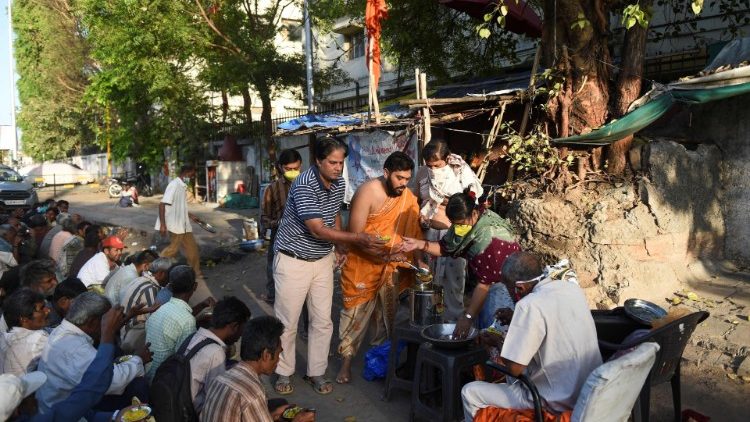Voluntários oferecem comida aos moradores de rua em Ahmedabad, na Índia