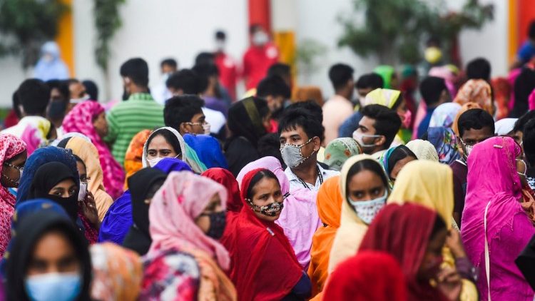 Trabalhadores esperam em filas para receber seu salário em uma fábrica de roupas durante a quarentena imposto pelo governo como medida preventiva contra a propagação do coronavírus COVID-19 em Savar 