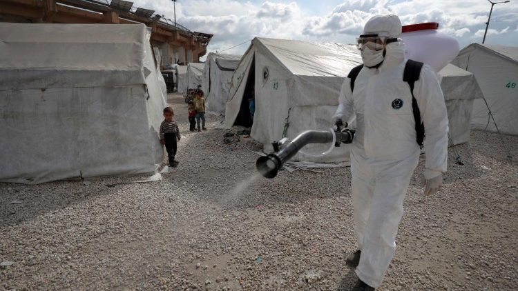 A sanitation worker disinfects a camp for displaced Syrians in Idlib
