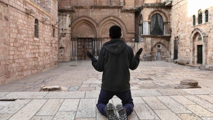 Християнин се моли пред затворените врати на Базиликата на Божи Гроб в Йерусалим