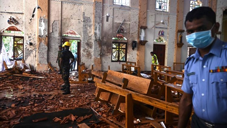 Policiais e militares olham destruição provocada pelas explosões na Igreja de São Sebastião