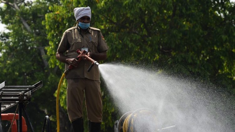 Trabajador desinfecta las calles en Nueva Delhi, India.