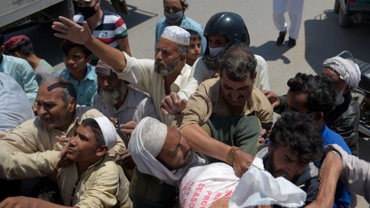 Pakistanis receiving food aid at a distribution point. 