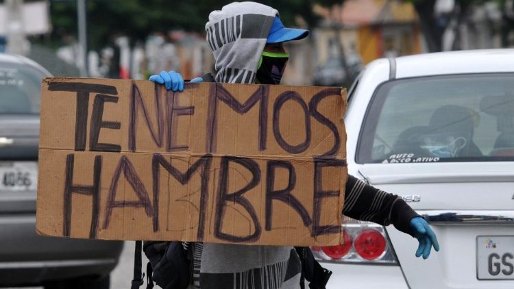 Um migrante da Venezuela ao expor cartaz que diz "Temos Fome"