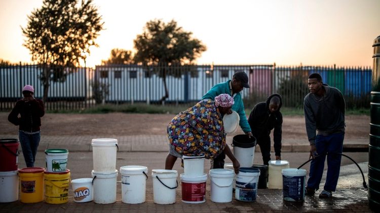 Des habitants d'un quartier pauvre de Johannesburg font la queue pour faire des réserves d'eau, le 24 avril 2020